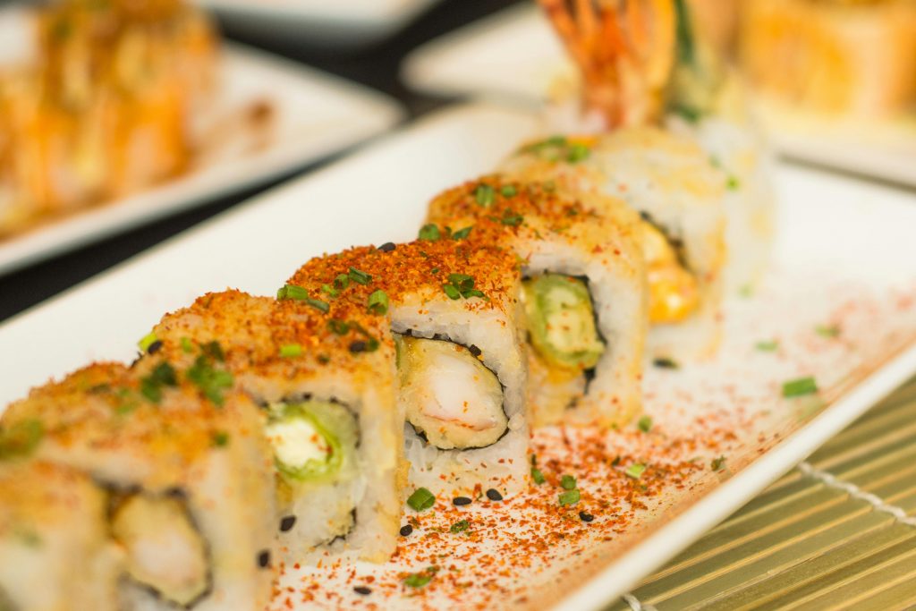 Close-up of delicious sushi roll with avocado, cream cheese, and shrimp.