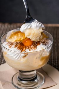 Indulge in this creamy dessert topped with whipped cream and garnished with fruit. Perfect for sweet lovers.